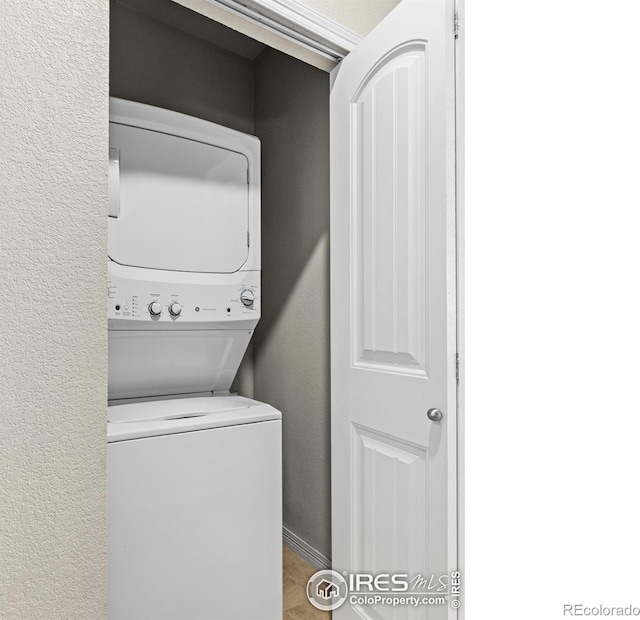 3038 County Fair Ln Unit 1, Fort Collins, CO 80528 - laundry room featuring stacked washer and clothes dryer and a textured wall