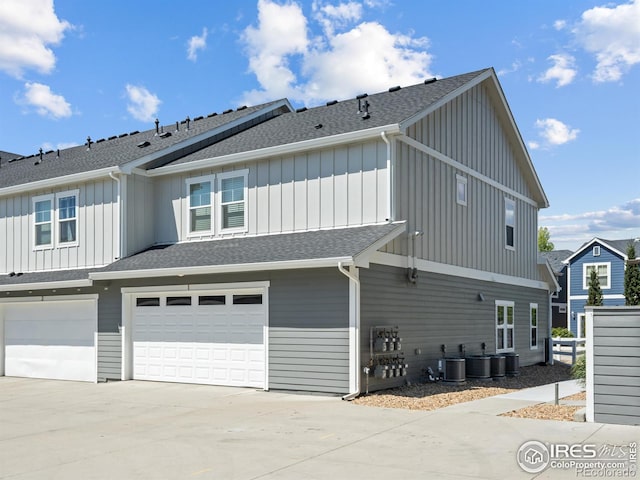3038 County Fair Ln Unit 1, Fort Collins, CO 80528 - view of home's exterior featuring board and batten siding, an attached garage, a shingled roof, and driveway