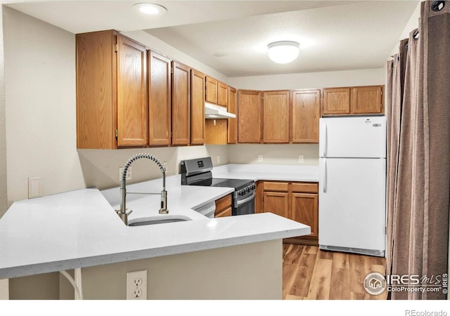 1830 W Centennial Dr Unit 108, Louisville, CO 80027 - kitchen featuring freestanding refrigerator, stainless steel range with electric stovetop, under cabinet range hood, light wood-style flooring, and light countertops