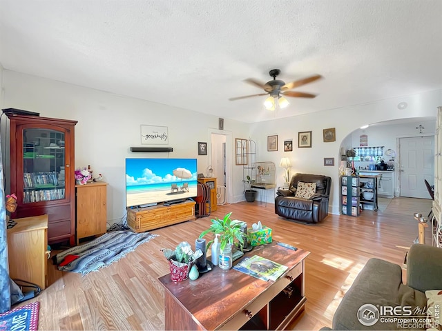 329 S Wynona Ave, Holyoke, CO 80734 - living area with ceiling fan, arched walkways, wood finished floors, and a textured ceiling