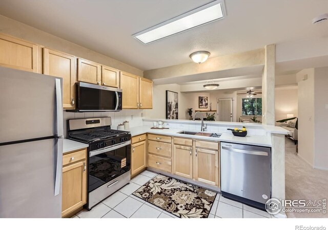 4919 Noble Park Pl, Boulder, CO 80301 - kitchen with stainless steel appliances, light brown cabinetry, a peninsula, and light countertops