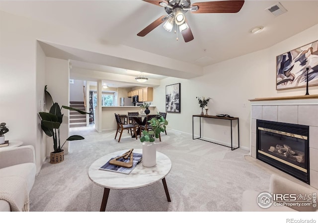 4919 Noble Park Pl, Boulder, CO 80301 - living area featuring light colored carpet, stairs, a tiled fireplace, and a ceiling fan