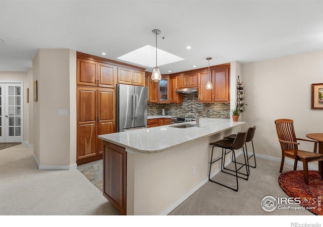 337 Arapahoe Ave Unit 303, Boulder, CO 80302 - kitchen featuring stainless steel refrigerator, light carpet, a peninsula, brown cabinetry, and recessed lighting