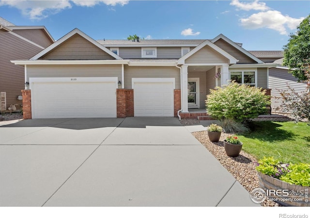 8119 Lighthouse Ln, Windsor, CO 80528 - craftsman house with a garage, concrete driveway, brick siding, and covered porch