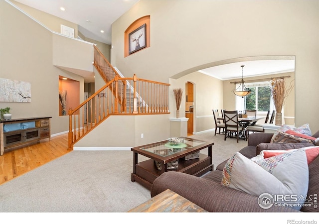 8119 Lighthouse Ln, Windsor, CO 80528 - carpeted living area featuring arched walkways, stairs, recessed lighting, and a towering ceiling