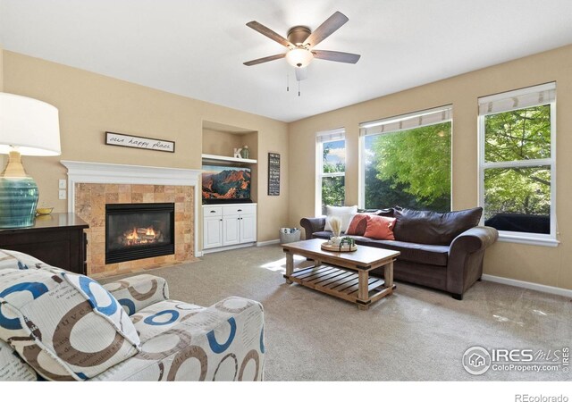 8119 Lighthouse Ln, Windsor, CO 80528 - living area with carpet floors, a tiled fireplace, a ceiling fan, and built in features