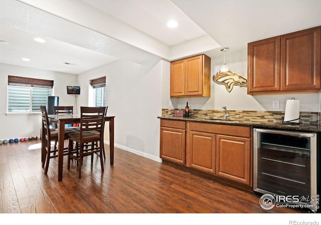8119 Lighthouse Ln, Windsor, CO 80528 - kitchen featuring beverage cooler, dark wood-style flooring, recessed lighting, brown cabinetry, and dark stone counters