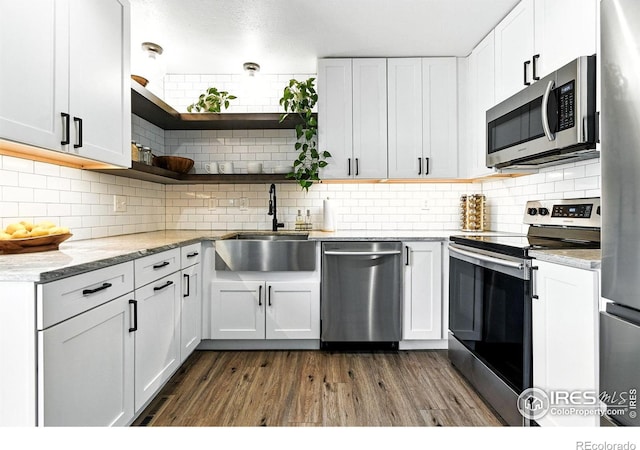 3850 Broadway St Unit 24, Boulder, CO 80304 - kitchen featuring appliances with stainless steel finishes, dark wood finished floors, decorative backsplash, open shelves, and white cabinetry