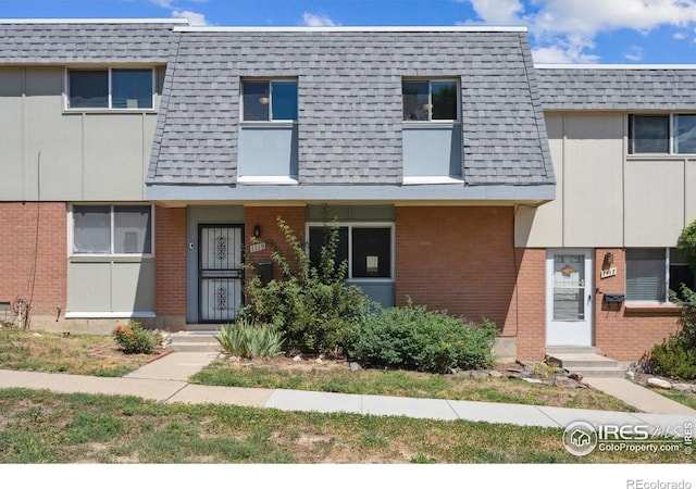 1119 Milky Way, Thornton, CO 80260 - view of property featuring brick siding, mansard roof, and a shingled roof