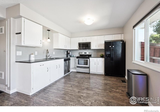 1119 Milky Way, Thornton, CO 80260 - kitchen with appliances with stainless steel finishes, dark countertops, backsplash, and dark wood-style floors