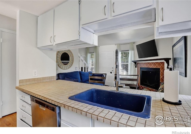 2279 Spruce St Unit 8, Boulder, CO 80302 - kitchen featuring dishwasher, a fireplace, white cabinetry, wood finished floors, and tile countertops