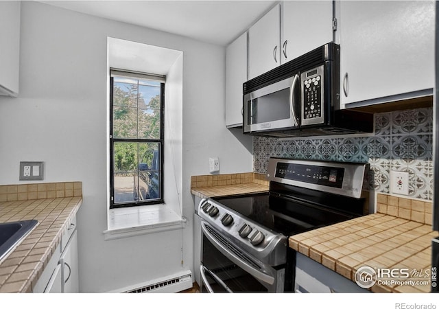 2279 Spruce St Unit 8, Boulder, CO 80302 - kitchen with stainless steel appliances, a baseboard heating unit, backsplash, and white cabinetry