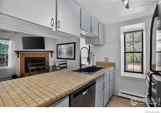 2279 Spruce St Unit 8, Boulder, CO 80302 - kitchen featuring stainless steel dishwasher, a tiled fireplace, healthy amount of natural light, and light tile patterned flooring