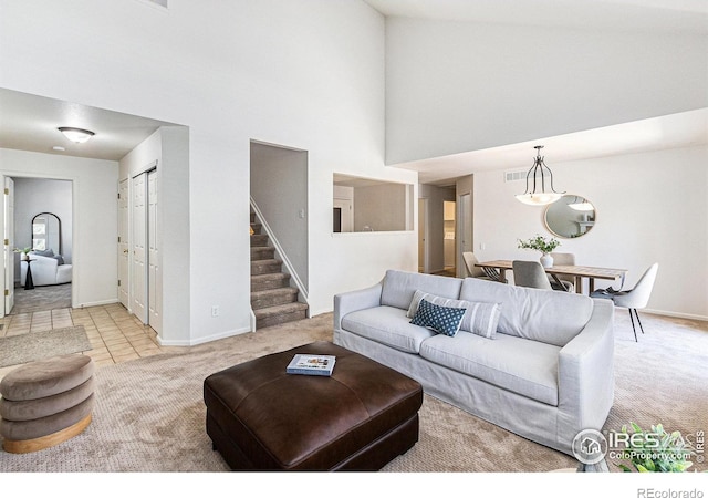 5124 Stillwater Creek Dr Unit E, Fort Collins, CO 80528 - living room featuring light colored carpet, a high ceiling, and stairway