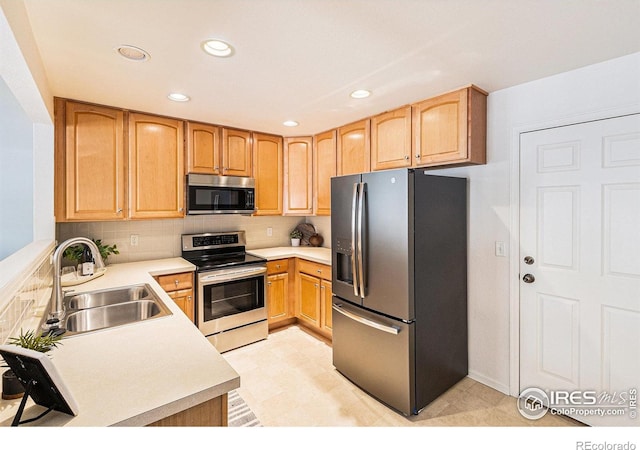 5124 Stillwater Creek Dr Unit E, Fort Collins, CO 80528 - kitchen featuring appliances with stainless steel finishes, recessed lighting, light countertops, tasteful backsplash, and light brown cabinetry