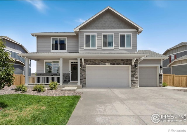 6818 Whisper Trail Ln, Wellington, CO 80549 - craftsman house with covered porch, driveway, a garage, and stone siding