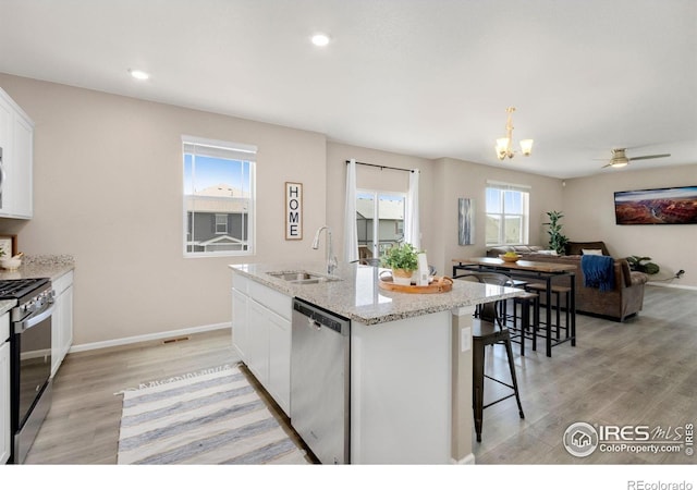 6818 Whisper Trail Ln, Wellington, CO 80549 - kitchen with stainless steel appliances, light wood-style floors, plenty of natural light, white cabinetry, and recessed lighting