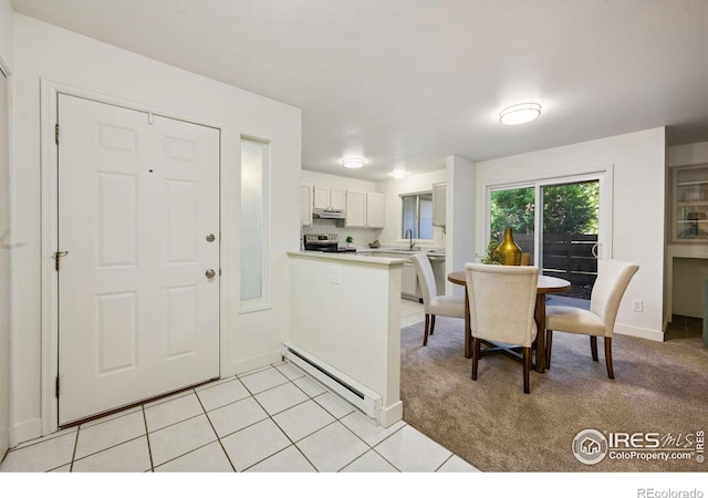 3465 Lochwood Dr Unit N-61, Fort Collins, CO 80525 - kitchen with a baseboard radiator, stainless steel electric range, under cabinet range hood, a peninsula, and white cabinets