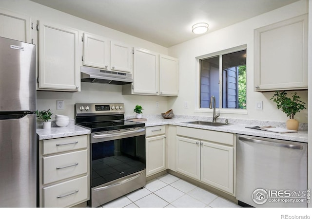 3465 Lochwood Dr Unit N-61, Fort Collins, CO 80525 - kitchen featuring appliances with stainless steel finishes, under cabinet range hood, light tile patterned flooring, and light stone counters