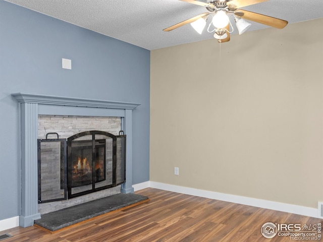 18931 E Brunswick Pl, Aurora, CO 80013 - detailed view of a warm lit fireplace, wood finished floors, a ceiling fan, and a textured ceiling
