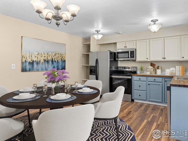 18931 E Brunswick Pl, Aurora, CO 80013 - dining room with a chandelier and dark wood-style floors