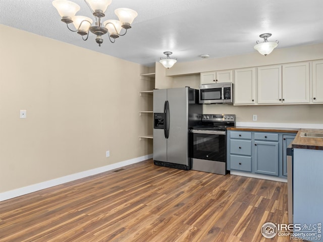 18931 E Brunswick Pl, Aurora, CO 80013 - kitchen with stainless steel appliances, butcher block counters, a chandelier, dark wood-type flooring, and white cabinetry