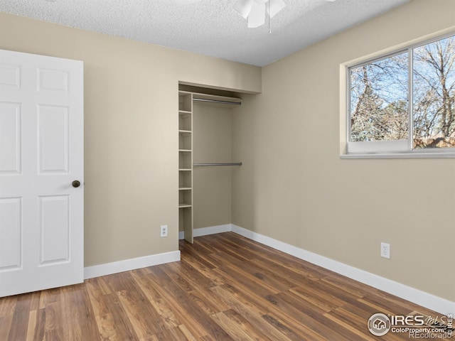18931 E Brunswick Pl, Aurora, CO 80013 - unfurnished bedroom featuring dark wood-style floors, a closet, and a textured ceiling