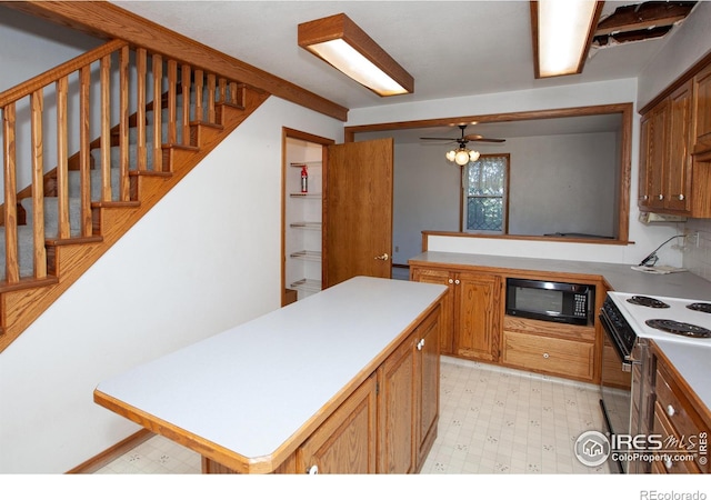 19089 Chambers Dr, Sterling, CO 80751 - kitchen with black microwave, white electric range oven, light countertops, light floors, and a center island