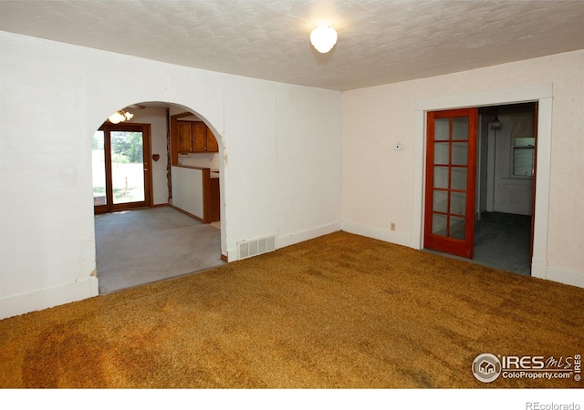 19089 Chambers Dr, Sterling, CO 80751 - unfurnished room featuring carpet flooring, arched walkways, and a textured ceiling