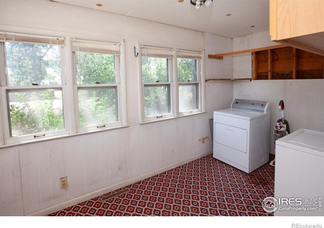 19089 Chambers Dr, Sterling, CO 80751 - washroom with healthy amount of natural light, separate washer and dryer, and wood walls