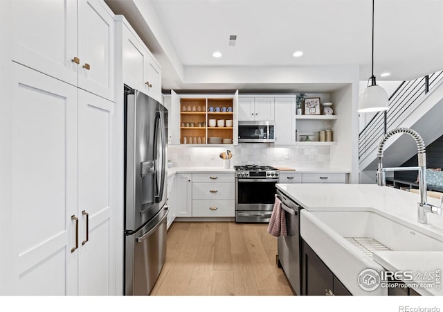 5223 Allison Way Unit D, Arvada, CO 80002 - kitchen featuring appliances with stainless steel finishes, open shelves, light wood finished floors, white cabinetry, and recessed lighting