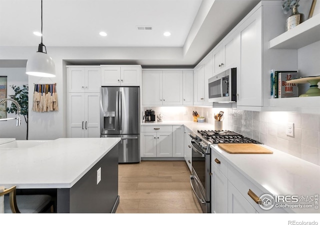5223 Allison Way Unit D, Arvada, CO 80002 - kitchen with stainless steel appliances, open shelves, white cabinets, backsplash, and recessed lighting