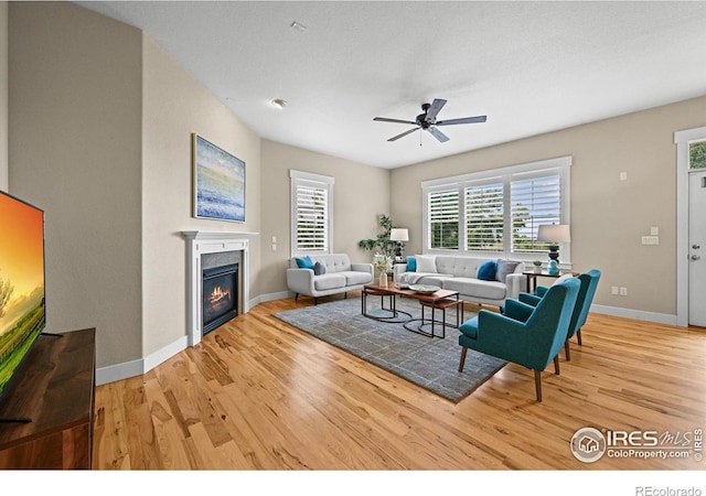 3031 Thunder Lake Cir, Lafayette, CO 80026 - living area featuring light wood finished floors, a glass covered fireplace, and ceiling fan