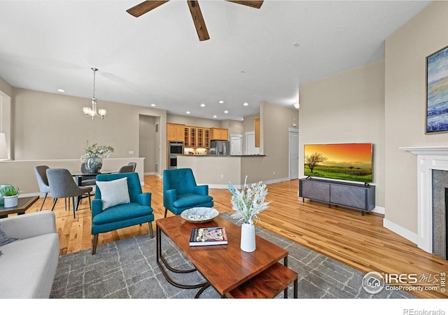 3031 Thunder Lake Cir, Lafayette, CO 80026 - living room with wood finished floors, ceiling fan, a chandelier, recessed lighting, and a fireplace