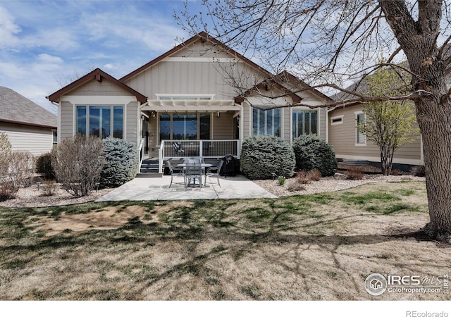 6771 Crooked Stick Dr, Windsor, CO 80550 - back of property with a patio area, board and batten siding, and a yard