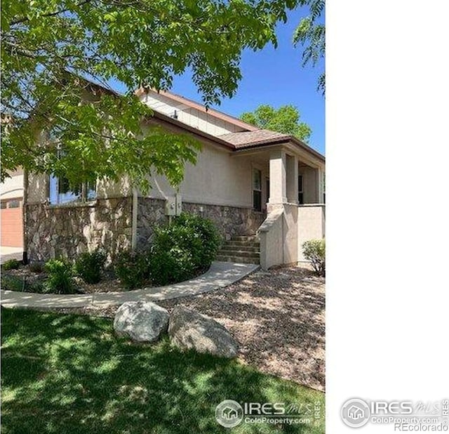 6771 Crooked Stick Dr, Windsor, CO 80550 - view of side of property with stone siding, stucco siding, and a lawn