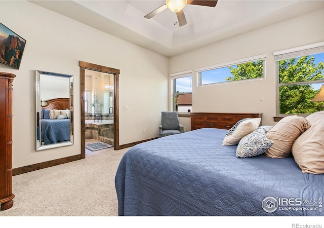 973 Skipping Stone Ct, Timnath, CO 80547 - carpeted bedroom with ensuite bath, a raised ceiling, and ceiling fan