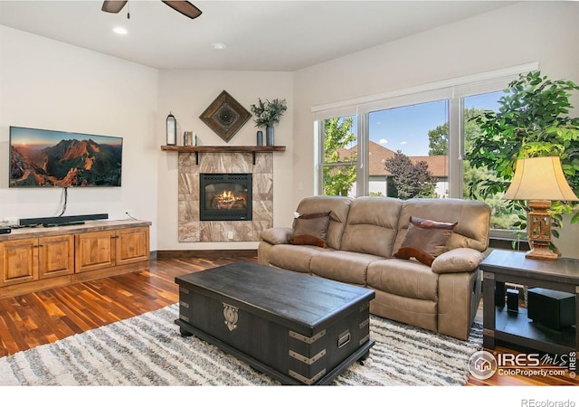 973 Skipping Stone Ct, Timnath, CO 80547 - living room with a ceiling fan, wood finished floors, a tiled fireplace, and recessed lighting