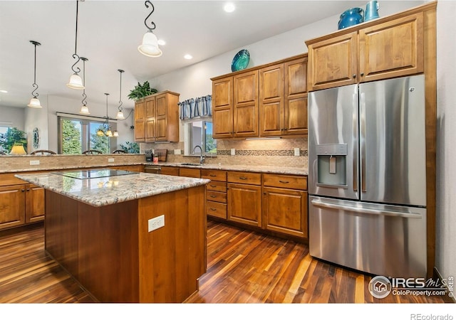 973 Skipping Stone Ct, Timnath, CO 80547 - kitchen featuring stainless steel fridge with ice dispenser, dark wood finished floors, brown cabinetry, tasteful backsplash, and recessed lighting
