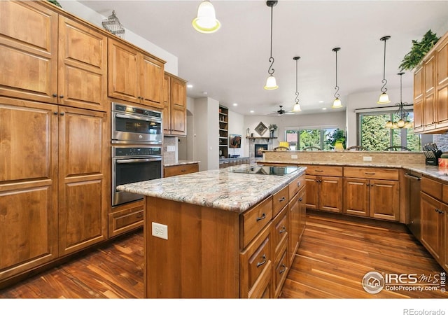 973 Skipping Stone Ct, Timnath, CO 80547 - kitchen with dark wood-type flooring, stainless steel appliances, a ceiling fan, brown cabinetry, and recessed lighting