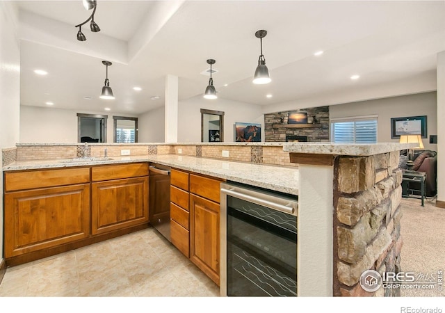 973 Skipping Stone Ct, Timnath, CO 80547 - kitchen featuring beverage cooler, a fireplace, open floor plan, stainless steel dishwasher, and brown cabinets