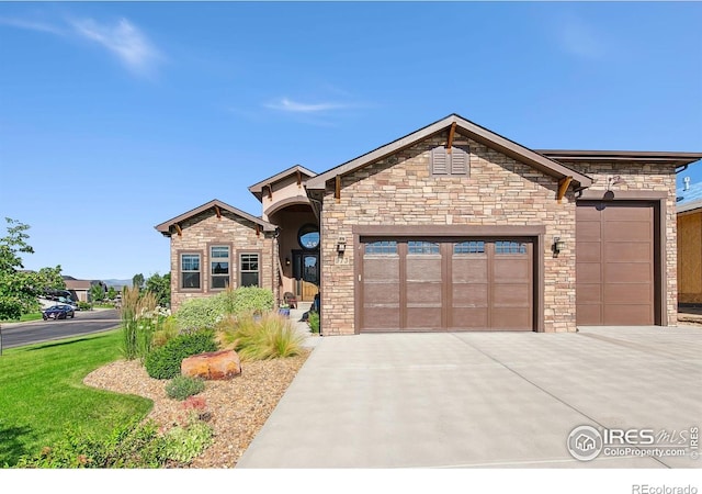 973 Skipping Stone Ct, Timnath, CO 80547 - view of front of house featuring a garage, driveway, and stone siding