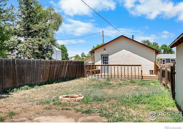 114 Berwick Ave, Firestone, CO 80520 - fenced backyard with a wooden deck and an outdoor fire pit