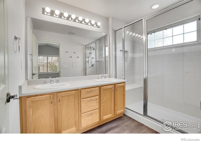 9266 W 107th Ln, Broomfield, CO 80021 - bathroom with double vanity, a shower stall, and wood finished floors