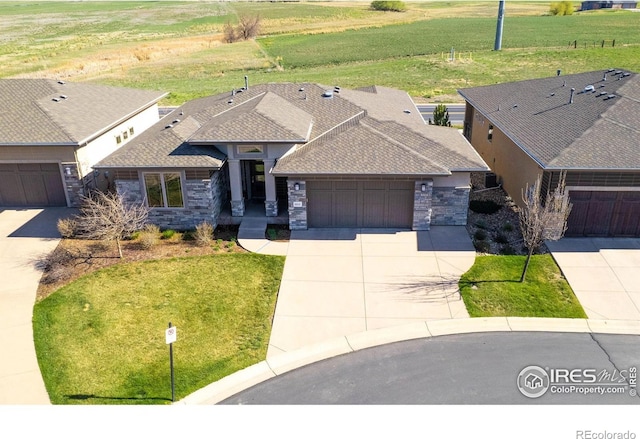 6928 Summerwind Ct, Timnath, CO 80547 - view of front of property with driveway, an attached garage, a shingled roof, stone siding, and a front yard