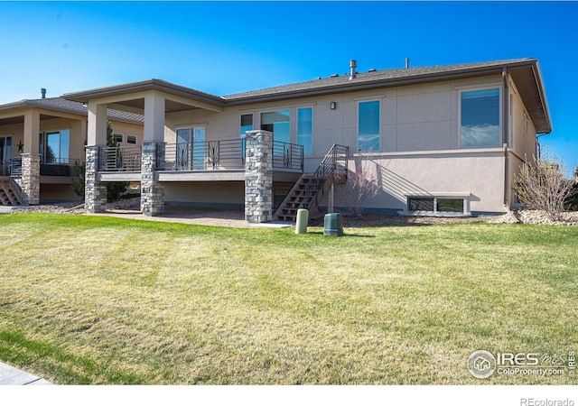 6928 Summerwind Ct, Timnath, CO 80547 - back of house with stairway, a yard, and stucco siding