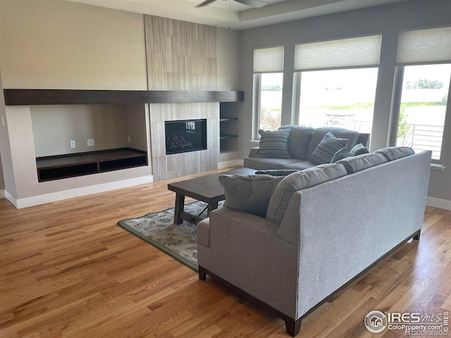6928 Summerwind Ct, Timnath, CO 80547 - living area with a tile fireplace, plenty of natural light, wood finished floors, and ceiling fan