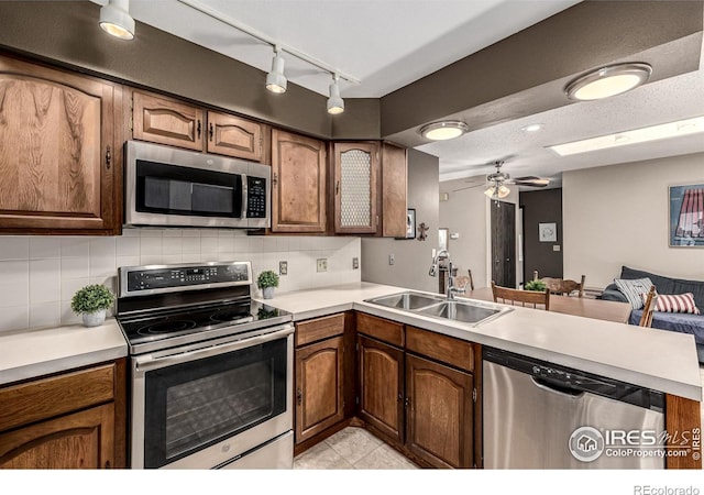 14 Douglas Dr N, Broomfield, CO 80020 - kitchen featuring appliances with stainless steel finishes, a peninsula, tasteful backsplash, and light countertops