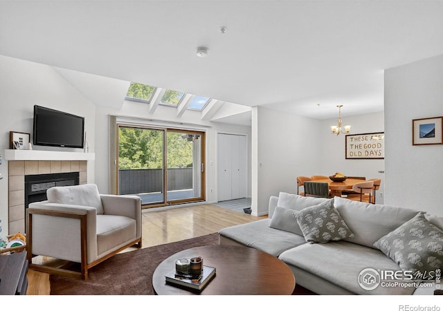 2954 Kalmia Ave # 34, Boulder, CO 80301 - living room featuring wood finished floors, a chandelier, a fireplace, and a skylight