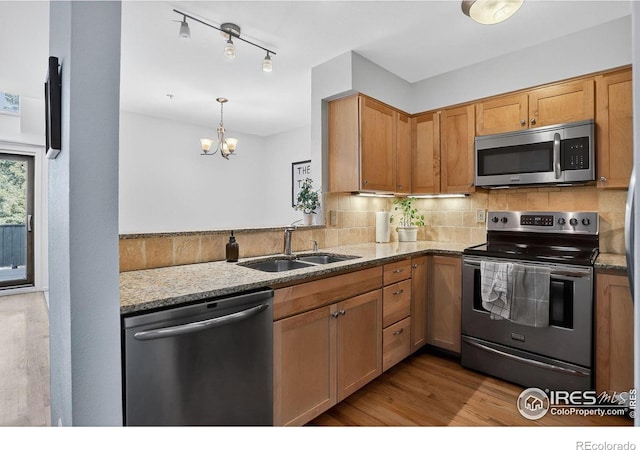 2954 Kalmia Ave # 34, Boulder, CO 80301 - kitchen with appliances with stainless steel finishes, tasteful backsplash, wood finished floors, light stone countertops, and a chandelier
